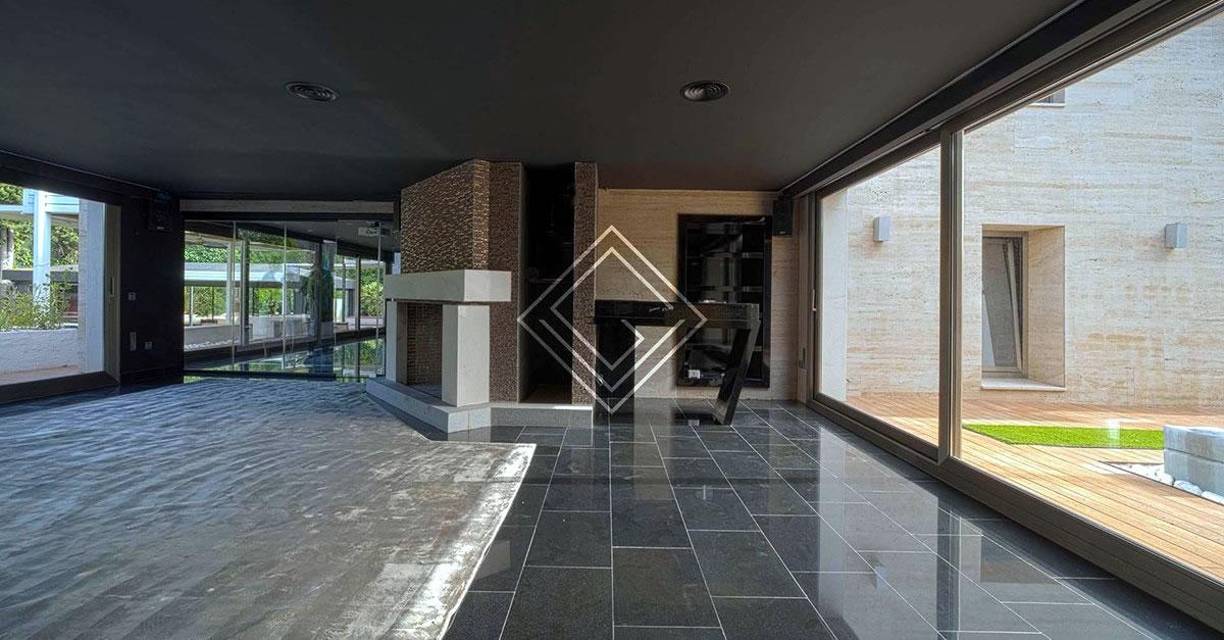 El inmenso vestíbulo de entrada, que dispone de un aseo de cortesía, da paso a un luminoso salón con grandes ventanales y con acceso directo al jardín.