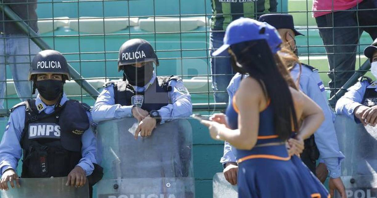 Dos elementos de la Policía Nacional en el momento que pasaban ante ellos dos hermosas edecanes.