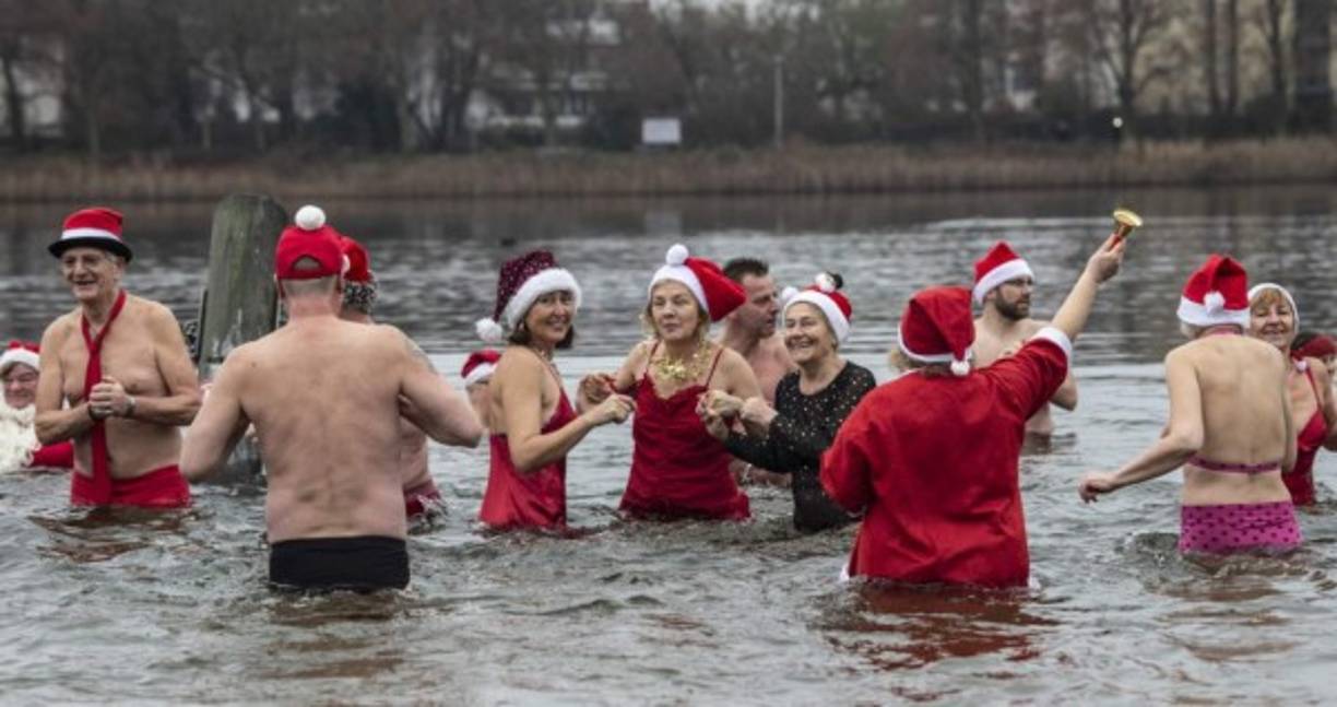 Miembros del club de natación Berliner Seehunde (focas de Berlín) toman su tradicional baño navideño en el lago Orankesee el 25 de diciembre de 2019 en Berlín.