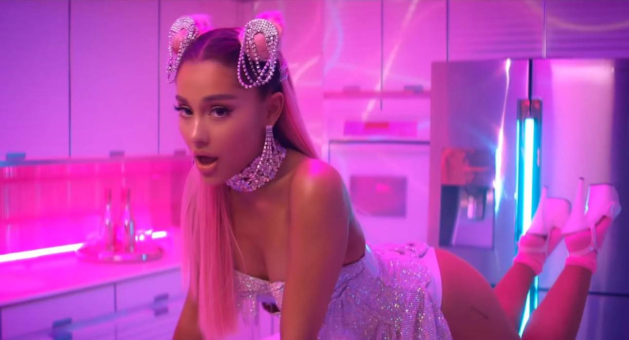 Ariana Grande es una figura muy femenina de la industria musical, en su tema “Seven rings”, la cantante nacida en Florida luce completamente “coquette”, de principio a fin, el film muestra escenografía rosada. Asimismo, ella aparece con un vestido de brillos y su cabello rosado, peinada con dos moñitos que le dan el toque especial. 