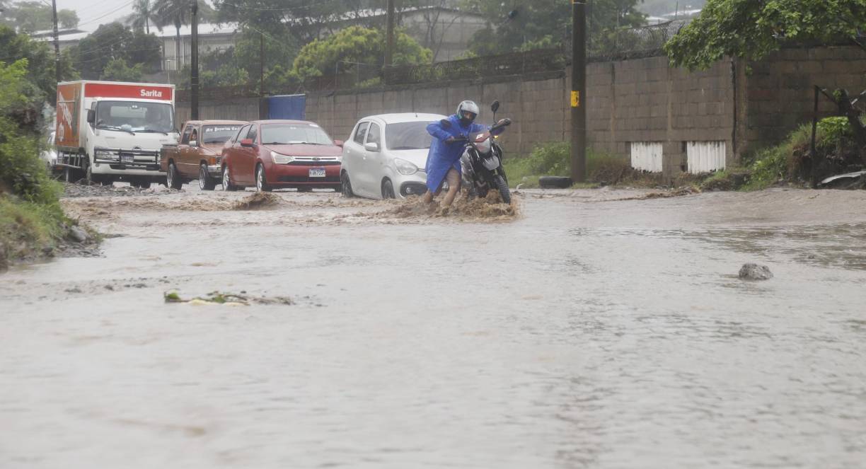 Un conductor de moto se arriesgo al cruzar la quebrada que separa la colonia Panting de Chamelecón con la 33 calle, y se apagó su moto por la fuerte corriente. Estuvo cerca de ser arrastrado.