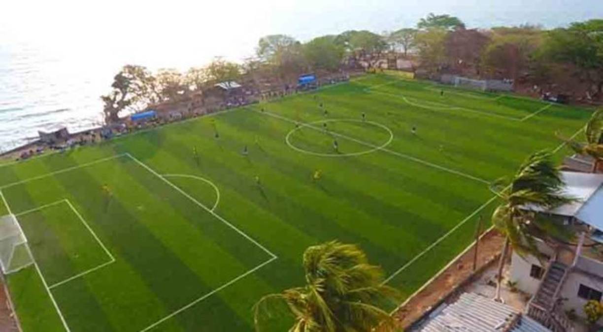 El campo cuenta con una grama sintética y regalemtarias para fútbol once.