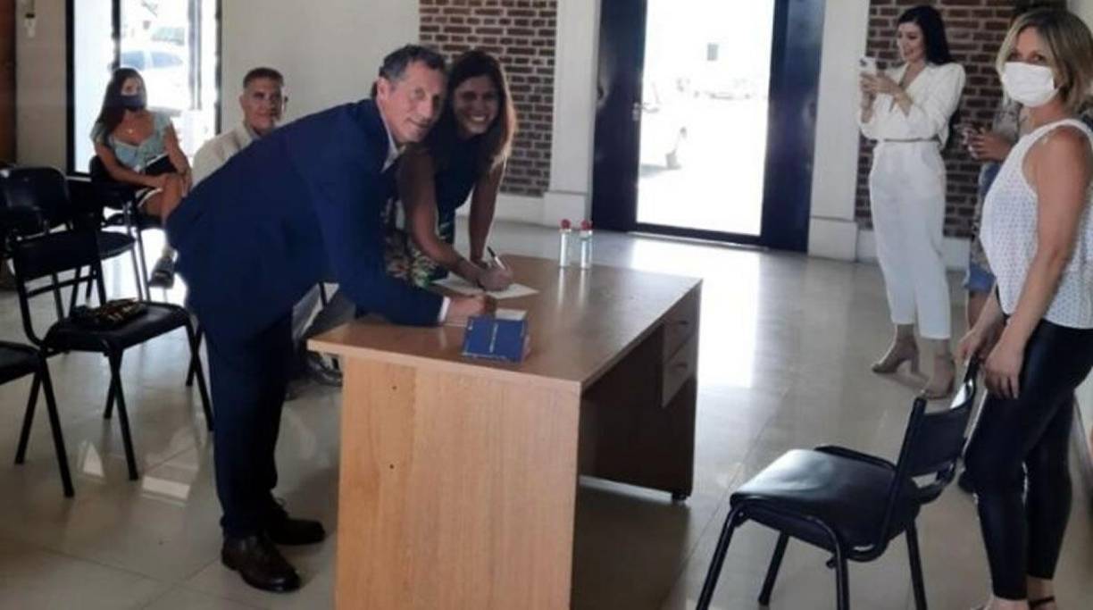 El técnico argentino firmando su compromiso matrimonial con Alejandra Alonso, madre de sus dos hijos pequeños.