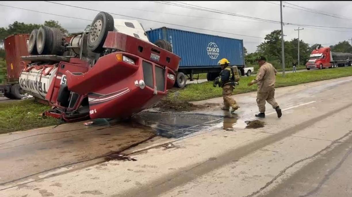 Bomberos intentan diluir el combustible derramado para evitar un incendio.