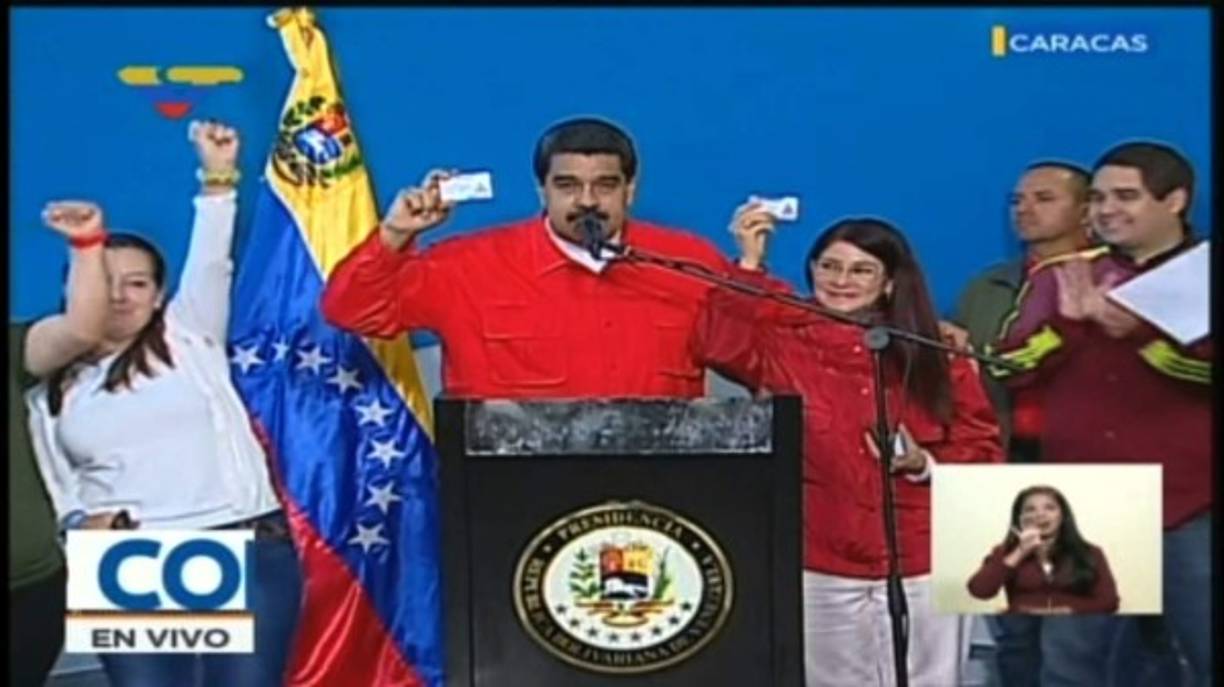 TV grab from Venezolana de Television (VTV) showing President Nicolas Maduro and Firts Lady Cilia Flores showing their 'Carnet de la Patria' -an electronic identity card aimed at organizing and regulating government social benefits- after casting their vote for Constituent Assembly in Caracas on July 30, 2017.<br/>Polls opened in Venezuela on Sunday for the election of a new, all-powerful 'Constituent Assembly' that President Nicolas Maduro promised would end his country's political and economic crisis by rewriting the constitution. / AFP PHOTO / VENEZUELAN TELEVISION (VTV) / TV Grab / RESTRICTED TO EDITORIAL USE - MANDATORY CREDIT 'AFP PHOTO / VENEZOLANA DE TELEVISION (VTV)' - NO MARKETING - NO ADVERTISING CAMPAIGNS - DISTRIBUTED AS A SERVICE TO CLIENTS<br/><br/>