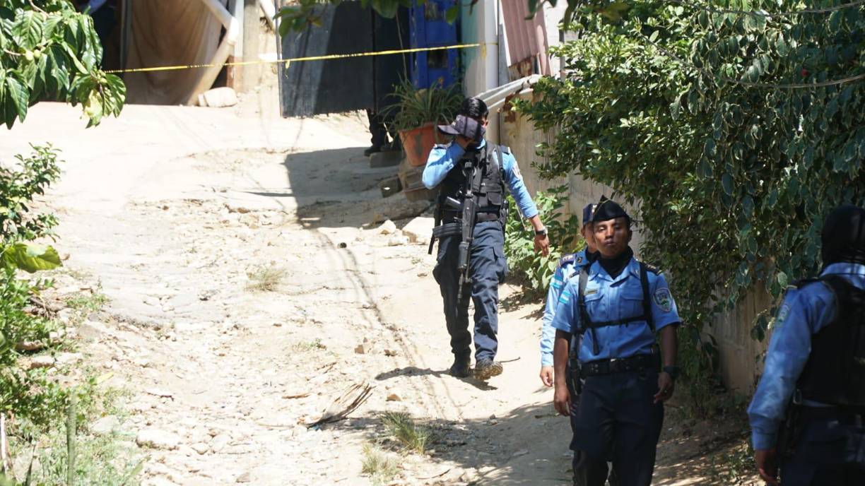 Agentes de la policía recorren la zona aledaña donde se cometieron los crímenes.