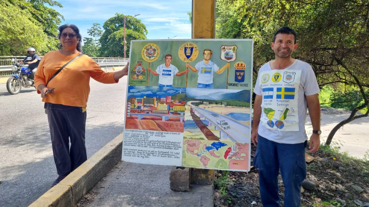 Doris Martínez Maestra maestra jubilada de Tegucigalpa compañera de hogar de Alexis Castillo, posan orgullosos junto al mural que pintaron en agradecimiento al Gobierno de Suecia por la donación de los puentes. 