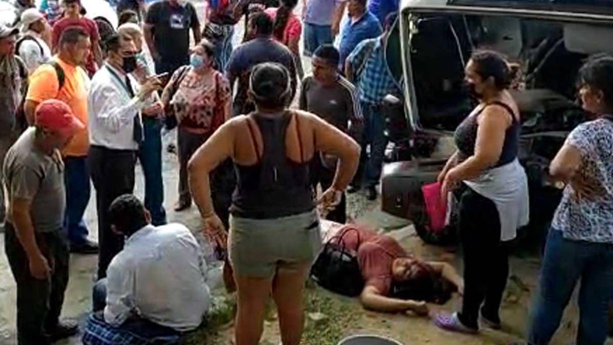 Una mujer pasajera está tendida en el suelo después que el bus se estrellara contra el muro.