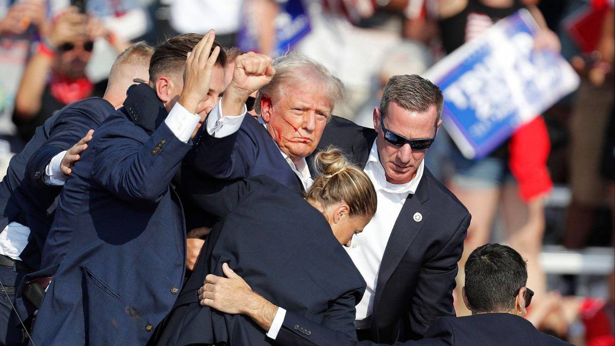 Dos semanas después, el 13 julio ocurre un intento de asesinato contra Trump. El exmandatario se encontraba dando un mítin en Butler (Pensilvania) cuando se oyen disparos y se agacha. Emerge después entre guardaespaldas, ileso salvo por una oreja ensangrentada y con el puño en alto, en una foto histórica.