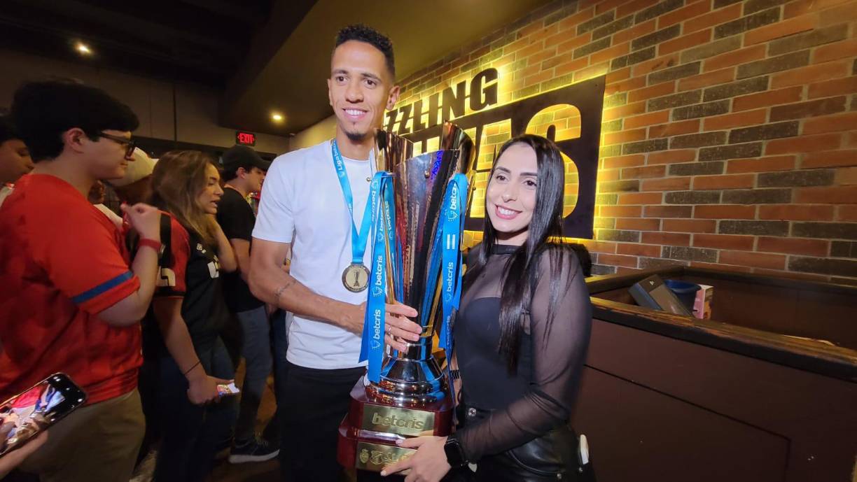 El volante brasileño junto a su novia y la Copa conquistada.