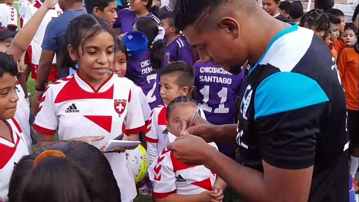El mediocampista hondureño Bryan Acosta firmando autógrafos a niñas mexicanas antes del entrenamiento.
