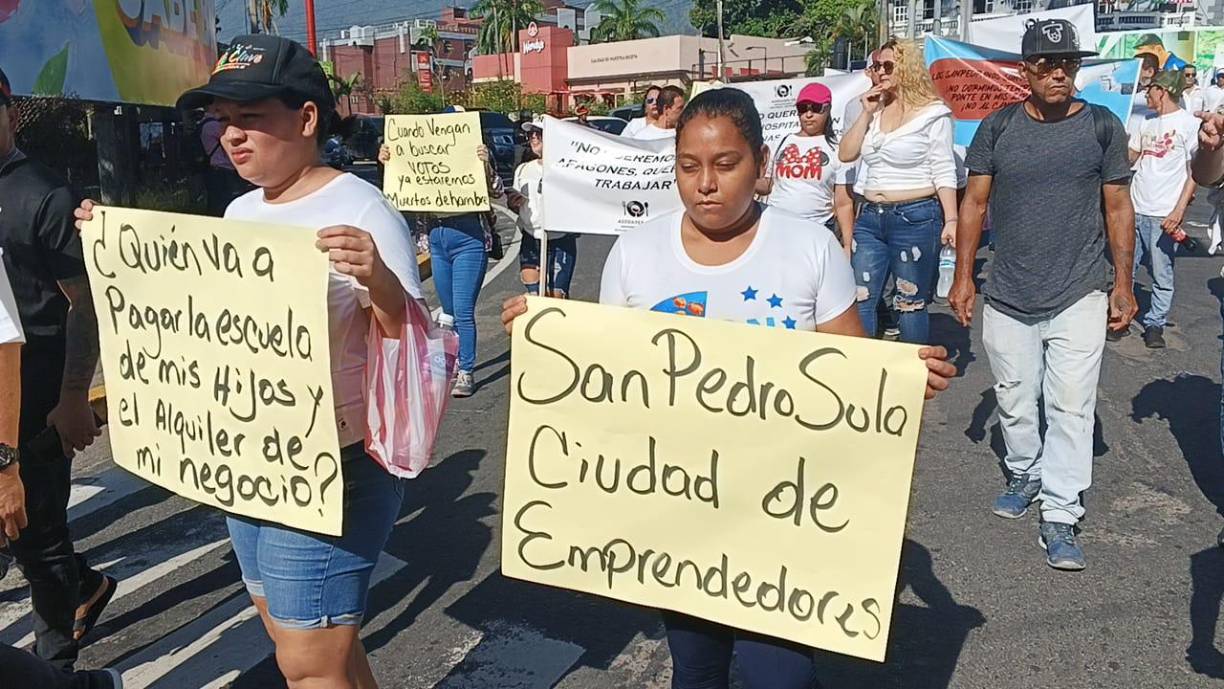 Los protestantes portaron pancartas con diversos mensajes en contra del toque de queda en la capital industrial. 
