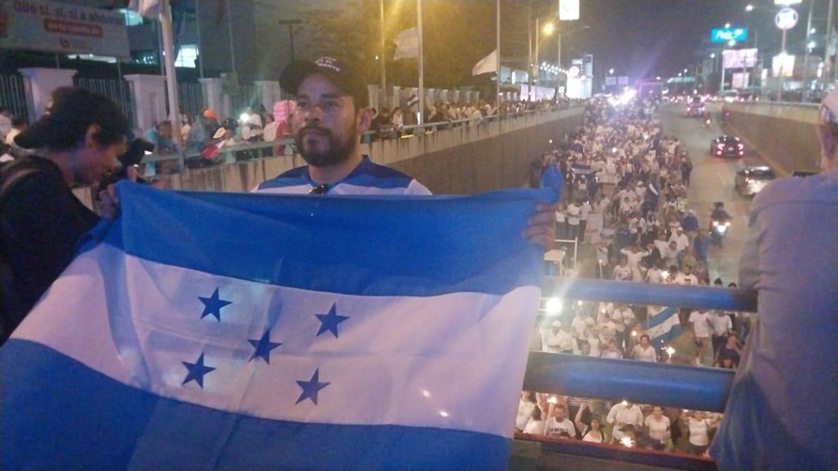 El grupo portando banderas de Honduras y antorchas fue creciendo a medida que avanzaron las horas.
