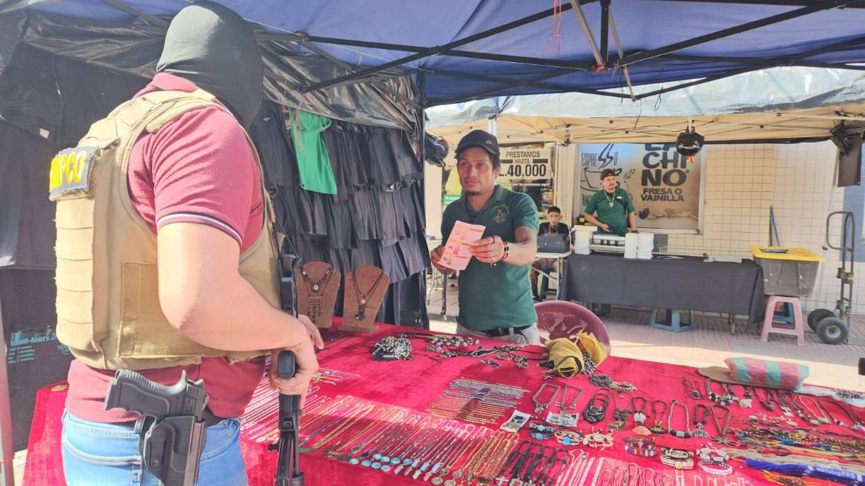 Uno de los vendedores en los alrededores del parque, recibe información de los agentes.