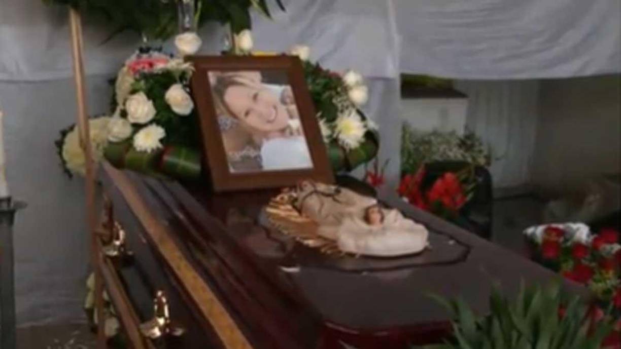  El féretro fue colocado en medio del patio, donde lo escoltan un par de coronas y otros arreglos florales.