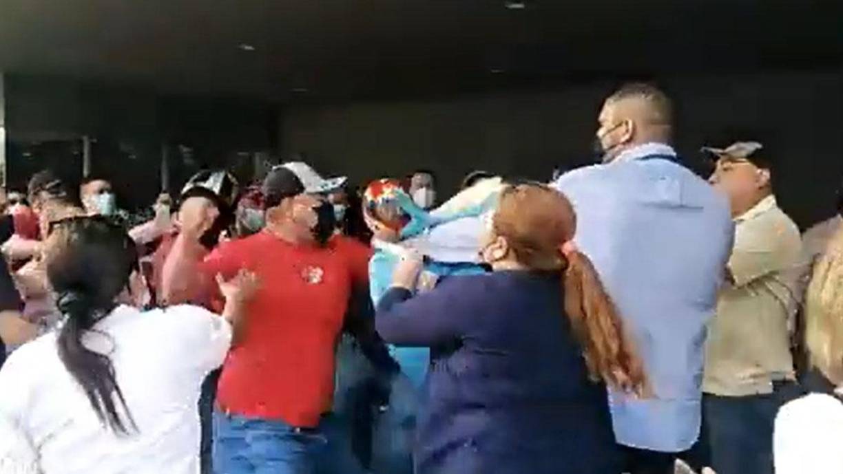 En esta imagen se ve a un miembro de Libre lanzar un puño a un empleado de la Secretaría del Trabajo.