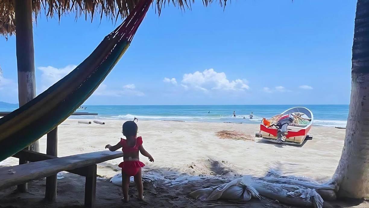 Donde está la lancha había agua, y donde está la bebé impactaban las olas. Así se ve ahora la playa de la Miami hondureña que desde noviembre del año pasado había comenzado a perder su playa. El mar amenazaba la aldea, su única calle y las construcciones turísticas del lugar.