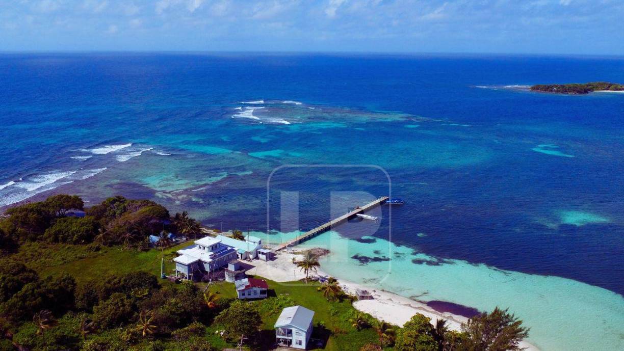 Hunting Caye y uno de sus dos muelles. En la parte trasera o norte de este cayo hay un faro. El cayo de enfrente es Lime Caye.