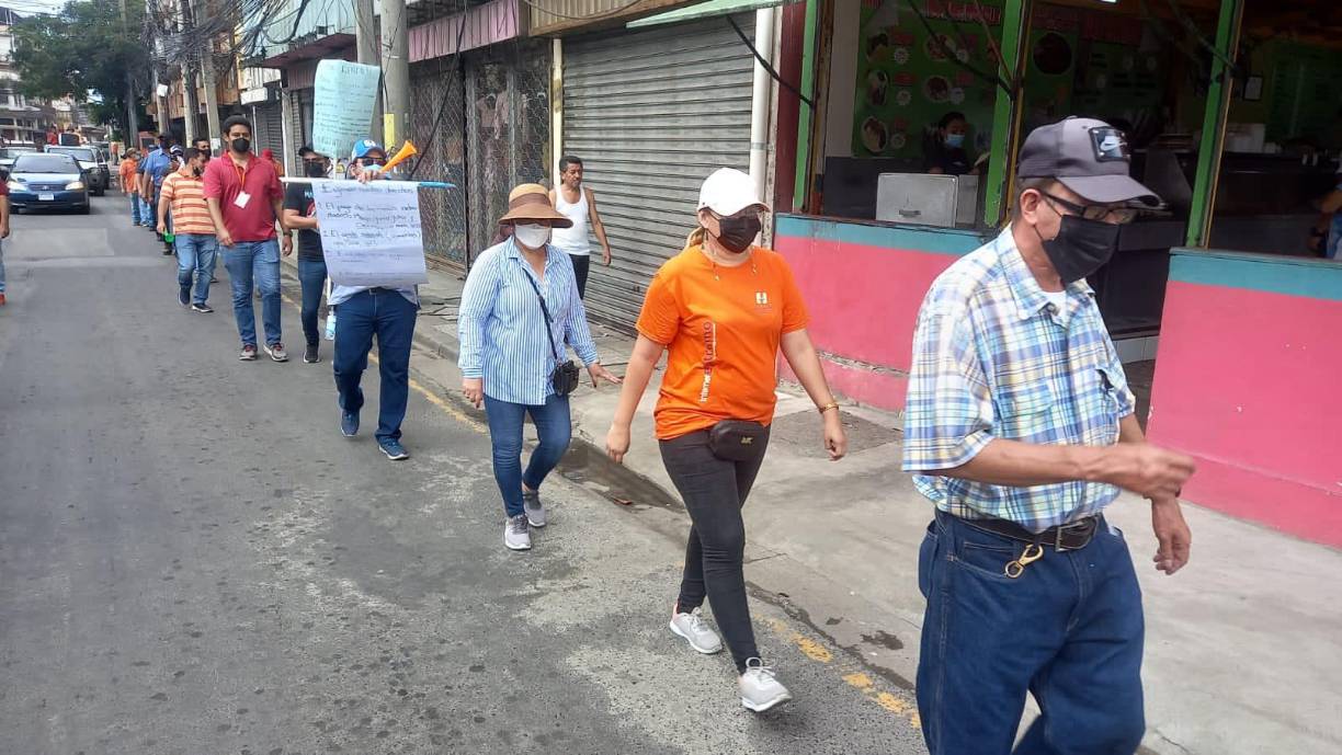 Los afectados caminando por la sexta avenida de San Pedro Sula.
