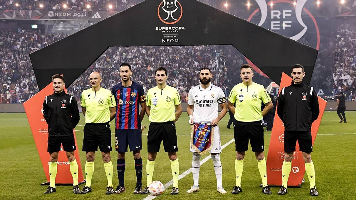 Los capitanes Karim Benzema y Sergio Busquets posando junto a la cuarteta arbitral de la final de la Supercopa de España.