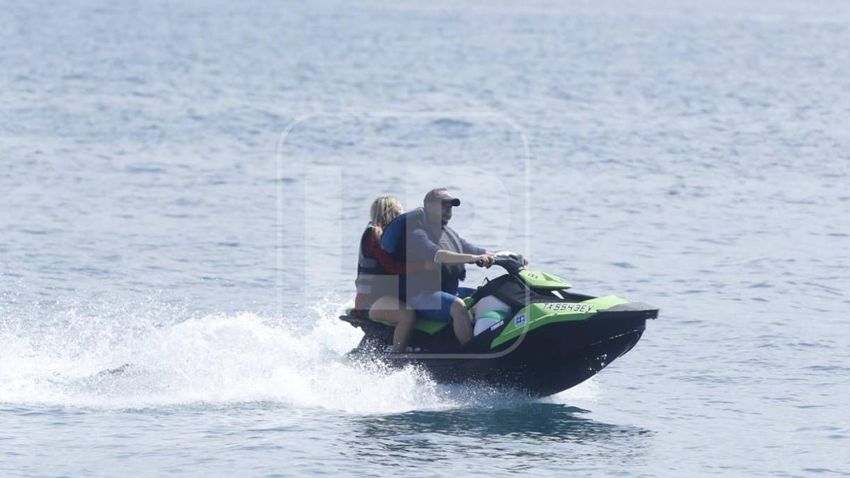 Una pareja da una vuelta en una moto acuática a la orilla de la playa de Tela.