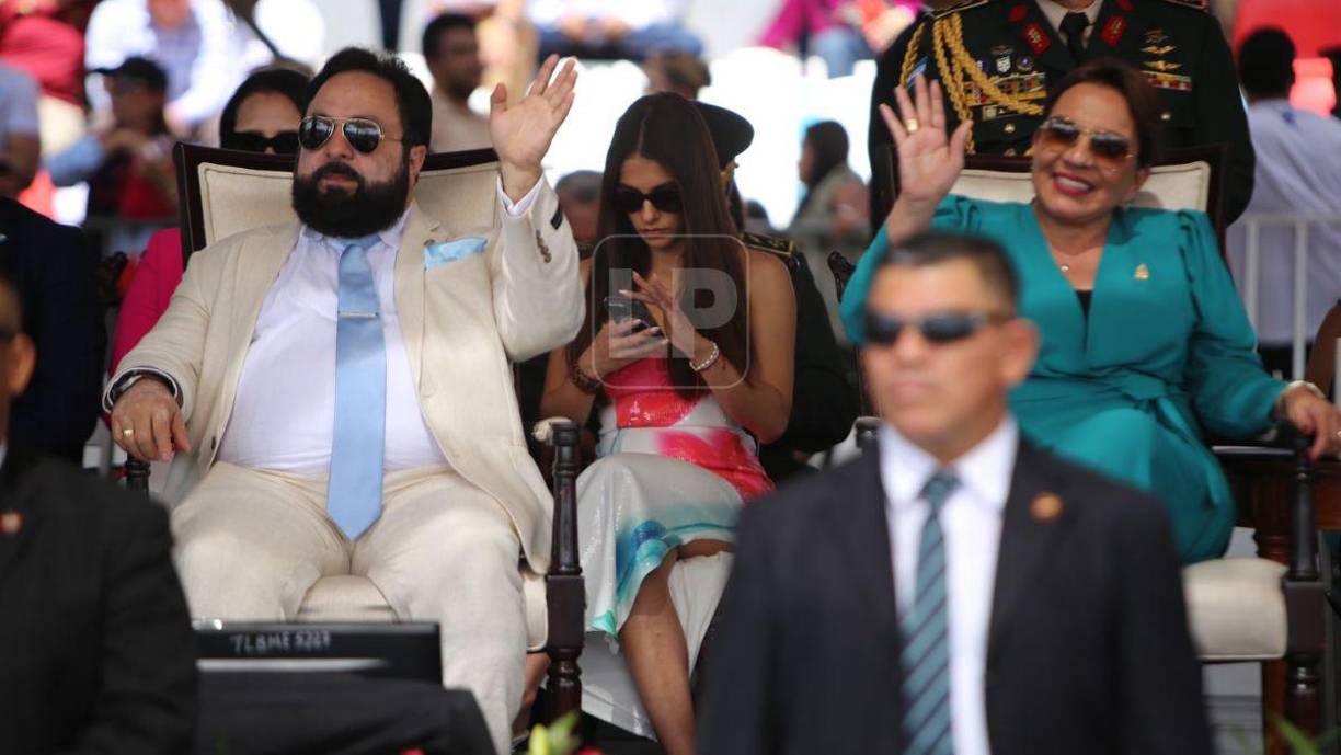 Utilizaba lentes de sol y permanecía detrás de las autoridades del gobierno.