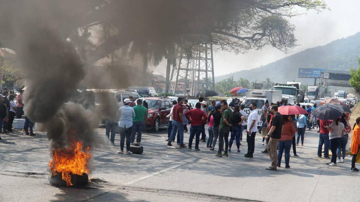 Las filas de vehículos y personas caminando por el bloqueo de la vía era interminable.