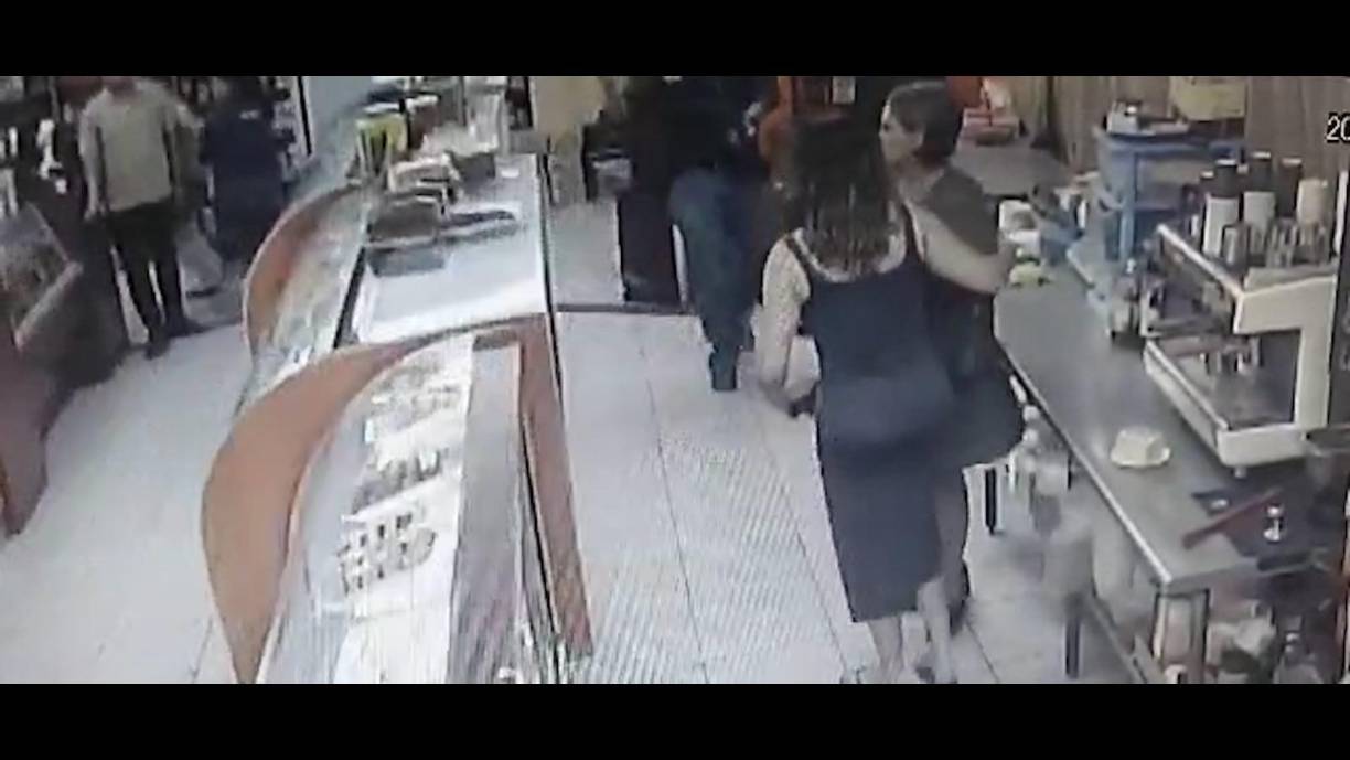 Cuando el sicario se va acercando a Erika Yulissa Bandy García, ella intenta ponerse a trás de una clienta.