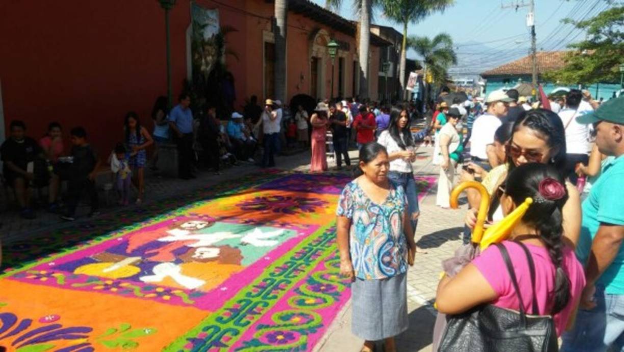 Un grupo de personas platica cerca de una de las alfombras en la ciudad de Comayagua, zona central de Honduras, en el marco del Viernes Santo, el 25 de marzo de 2016.