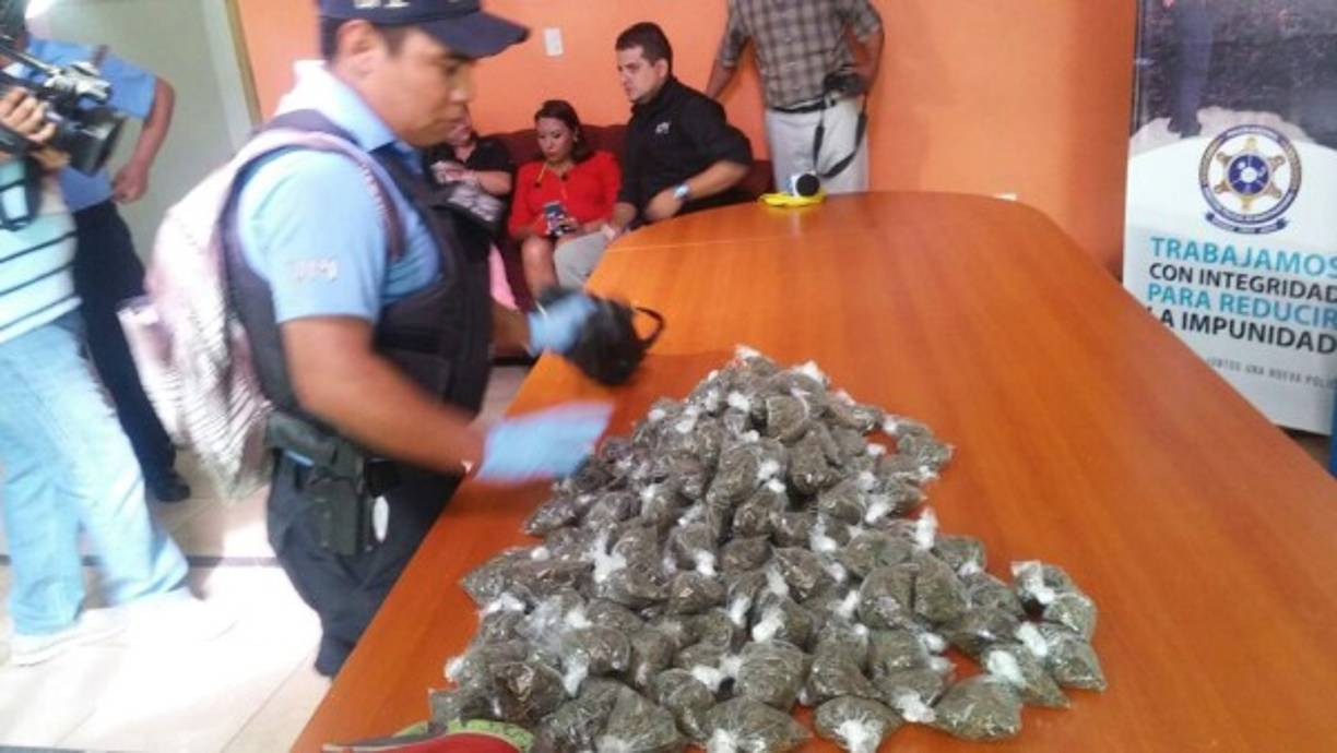 Un policía en las instalaciones de la Dirección Policial de Investigaciones (DPI) participa en la presentación de personas detenidas y droga decomisada.