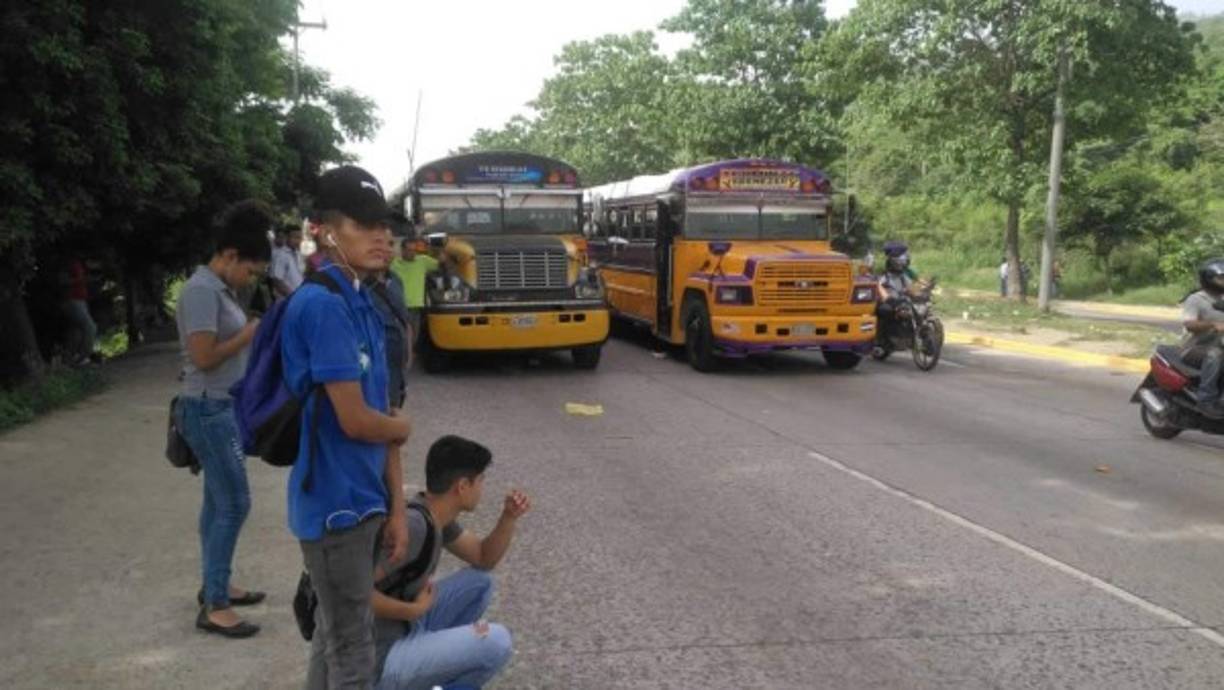 Jóvenes esperan a que una unidad de transporte los lleve a su trabajo; pero hay un paro de labores que lo impide.