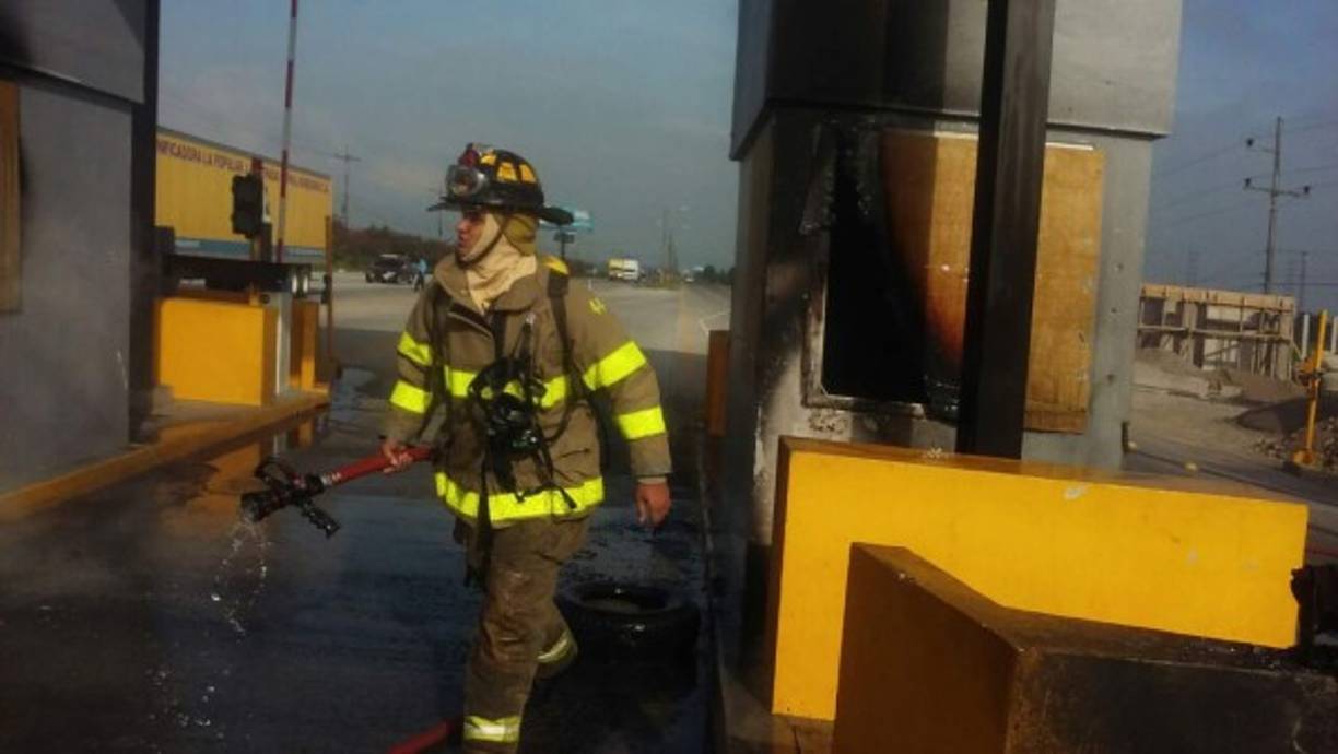 Un elemento del Cuerpo de Bomberos de Honduras tras apagar las llamas en las casetas de peaje en El Progreso, Yoro.