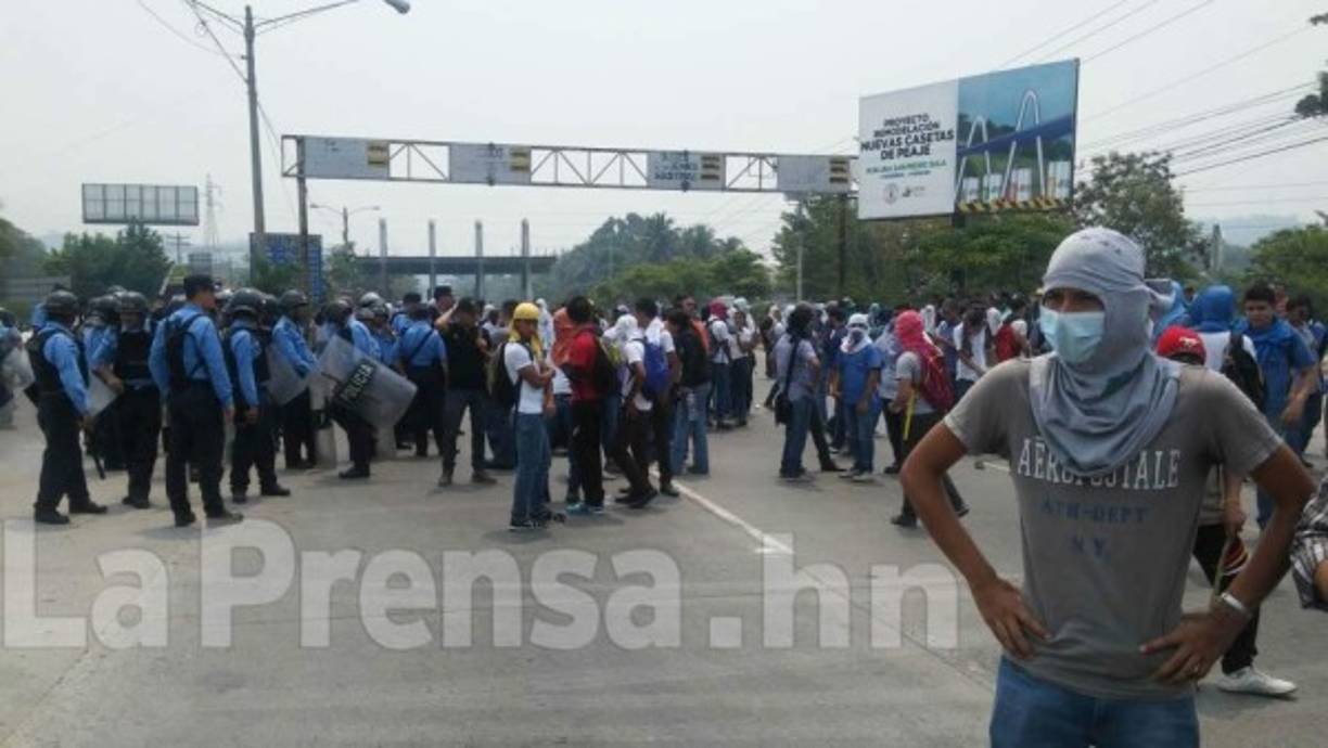 Un estudiante con el rostro cubierto participa en una protesta el miércoles 11 de mayo de 2016 en la cual se tomó el peaje norte de San Pedro Sula.