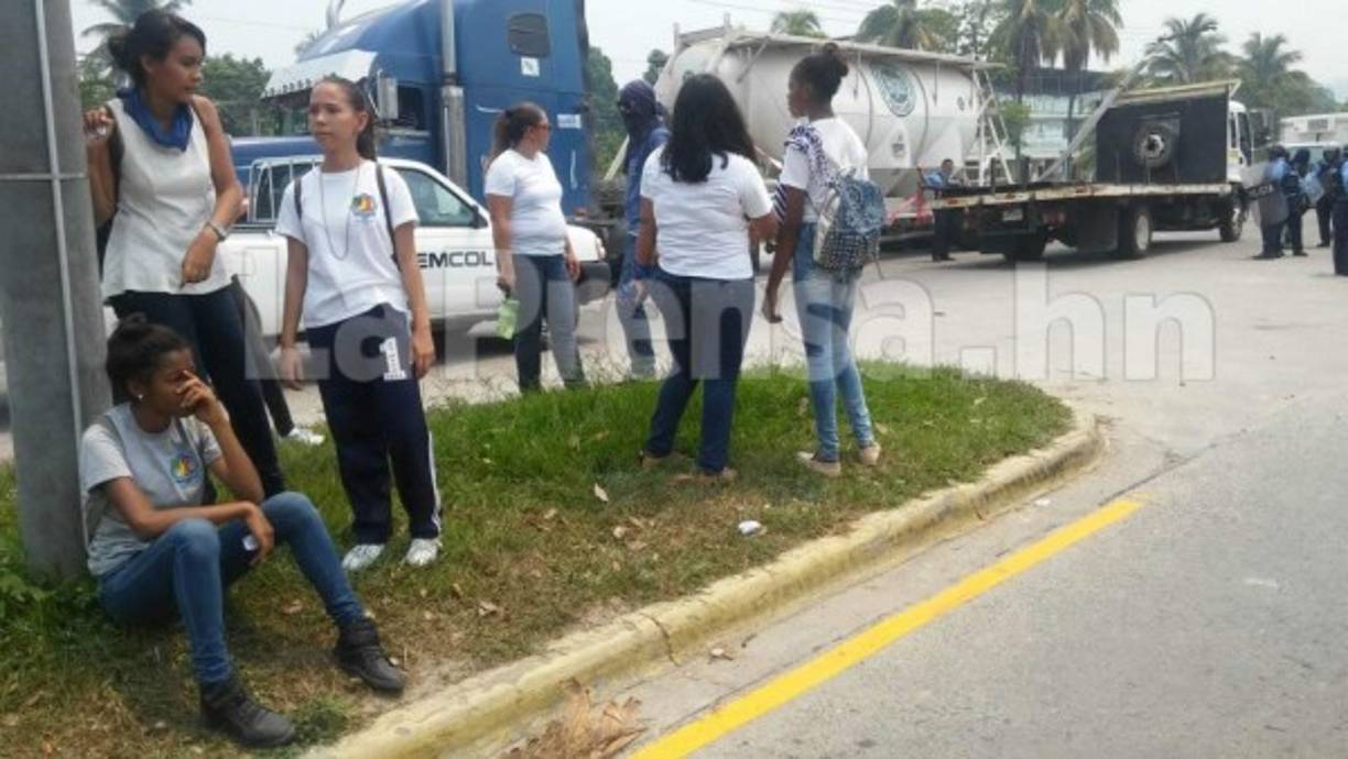 Una joven estudiante se sentó a descansar en medio de una protesta con toma de peaje en la ciudad de San Pedro Sula.