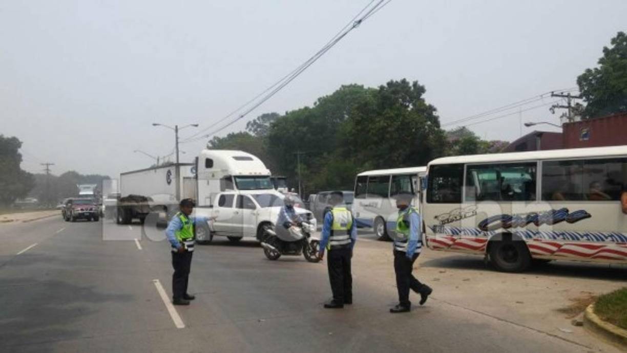 Los vehículos pasando lentamente por una trocha debido a la protesta de un grupo de estudiantes que argumentan abusos de poder de parte de Marlon Escoto.