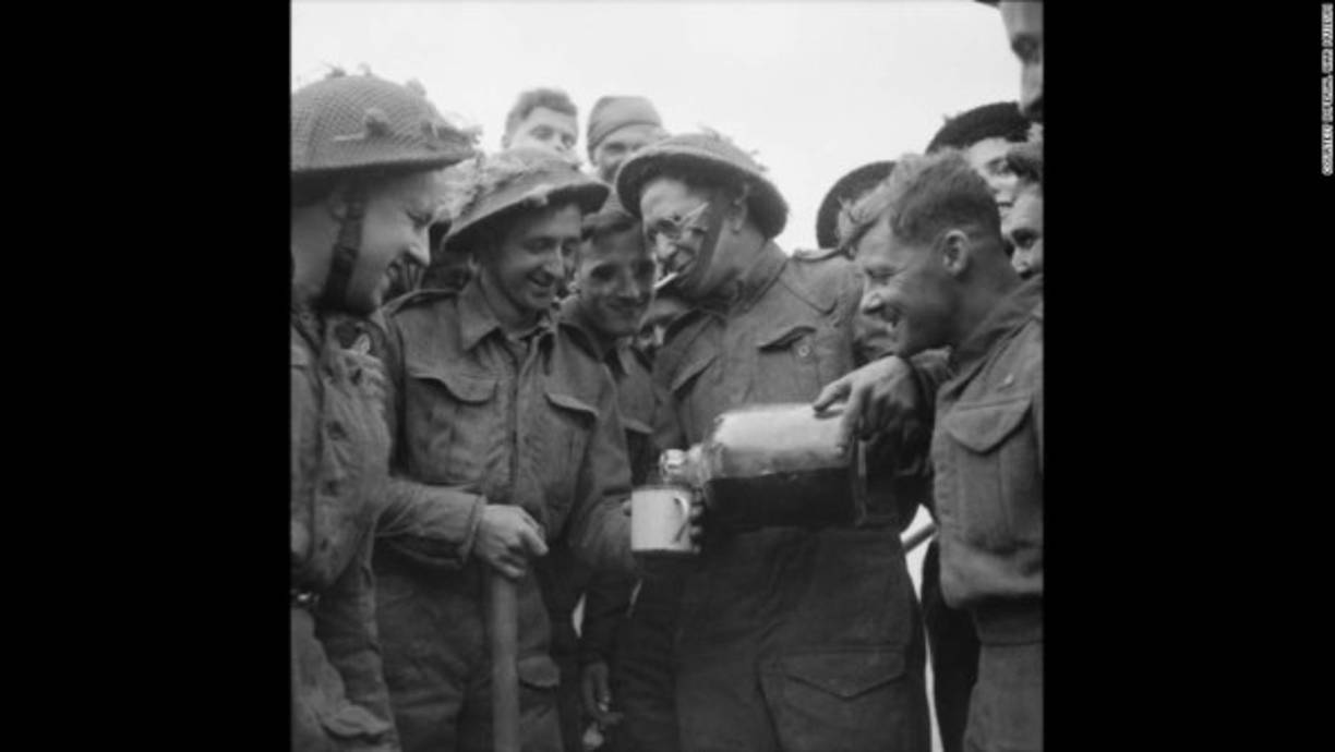 El soldado Walter Ray del ejército británico comparte una botella de ron que encontró flotando en el mar.
