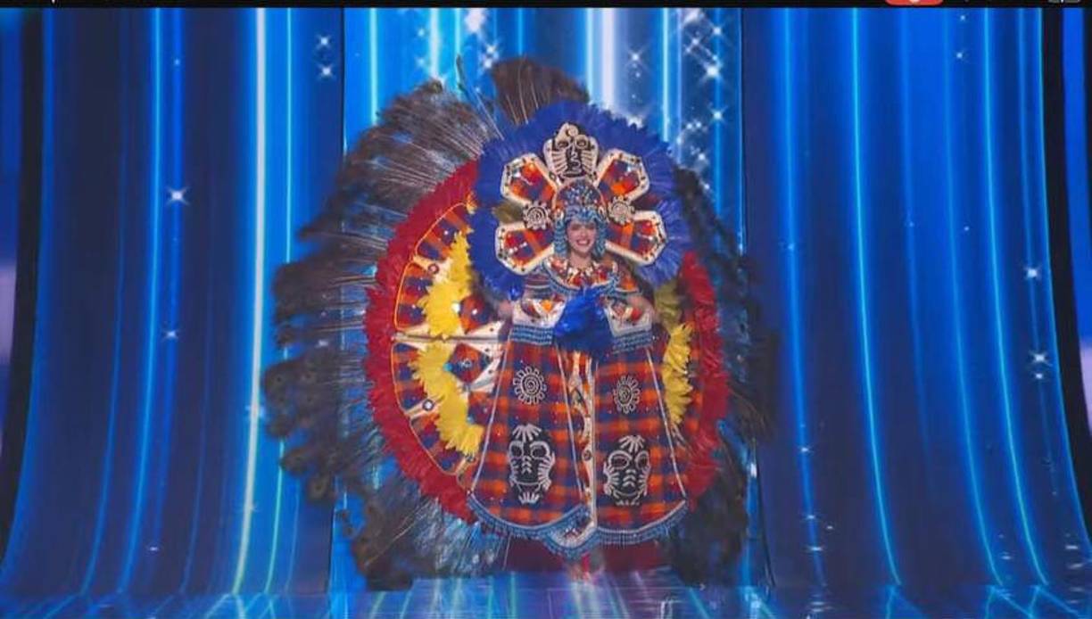 La pieza, nombrada “Artesana Lenca, orgullo catracho”, utiliza 10 yardas de telar lenca en los colores de la Ara Macao (Guacamaya) - rojo, azul y amarillo -, confeccionado en la comunidad de El Cacao, Intibucá, al oeste de Honduras.