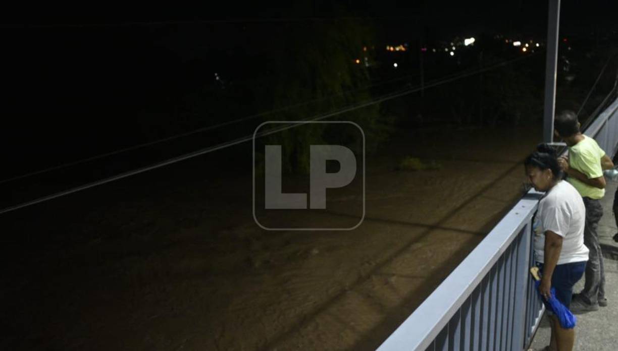 En el puente La Democracia, de El Progreso, Yoro, el Ulúa es vigilado por pobladores. El río es causante de las inundaciones más trágicas en la región.