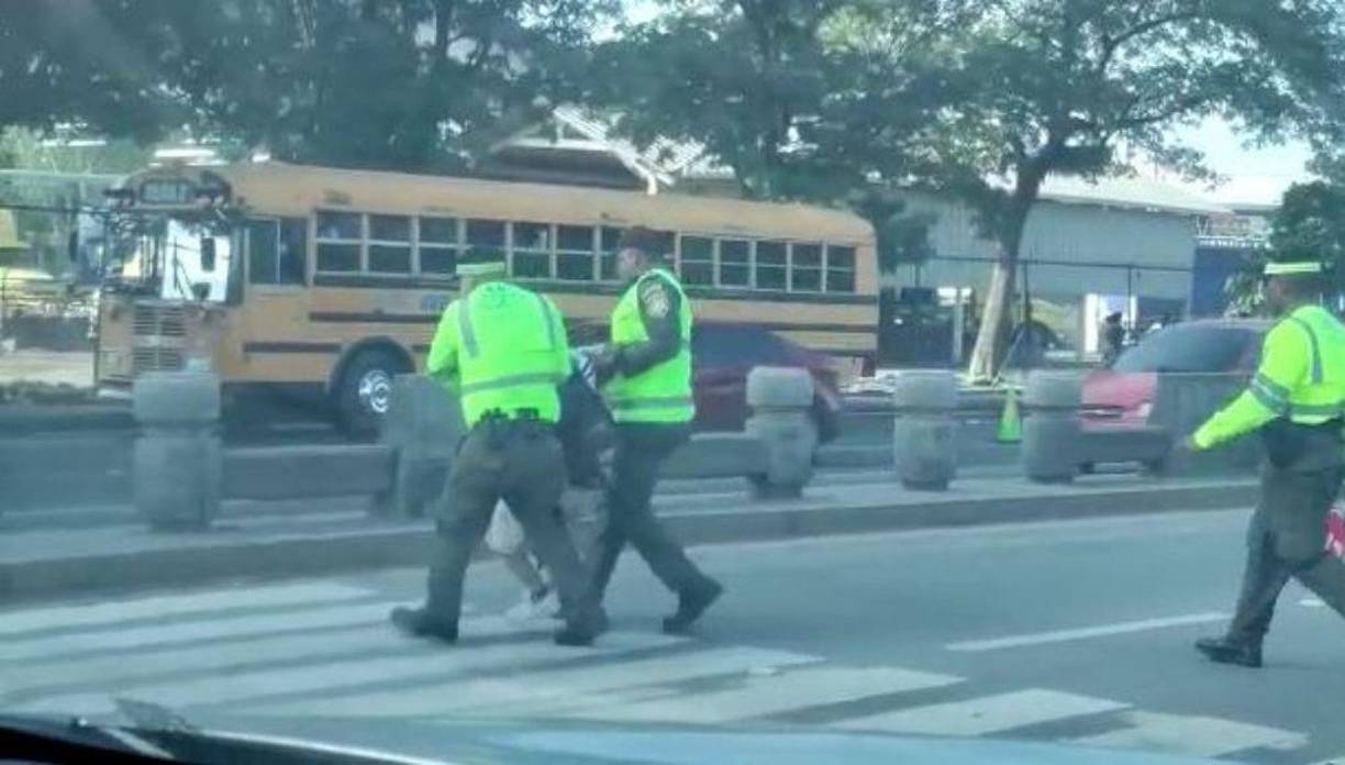 Un tercer policía se sumó a la acción. Tomó la señal de “alto” para detener el tráfico. 