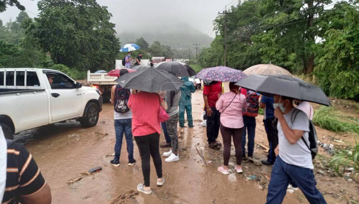 Algunos ciudadanos se bajaron de sus vehículos hasta esperar que la lluvia disminuyera. 