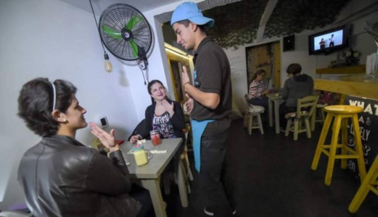 Los clientes se dividen casi por igual entre oyentes y no oyentes. La música está al mismo nivel auditivo que en un bar convencional. La diferencia es que aquí las manos son las protagonistas.( Foto:AFP)