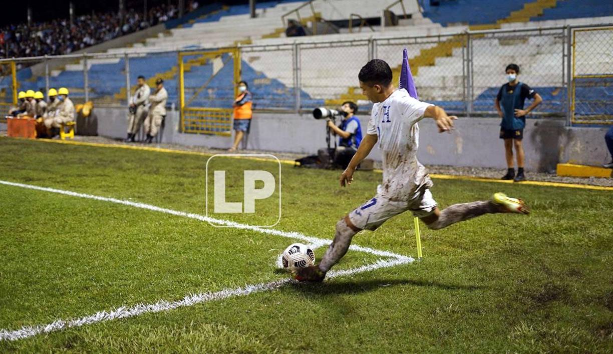 El hondureño Odin Ramos, cubierto de lodo, cobrando un tiro de esquina.