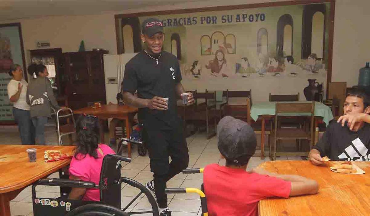 Romell Quioto en el momento que le entregaba refresco a los jóvenes de la Casa Hogar. 