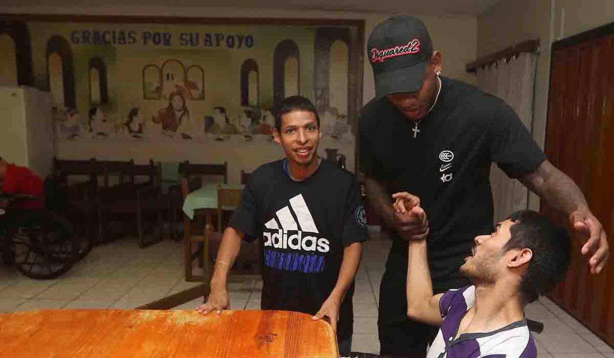 Romell Quioto abrazando a los chicos que forman parte de la Casa Hogar.