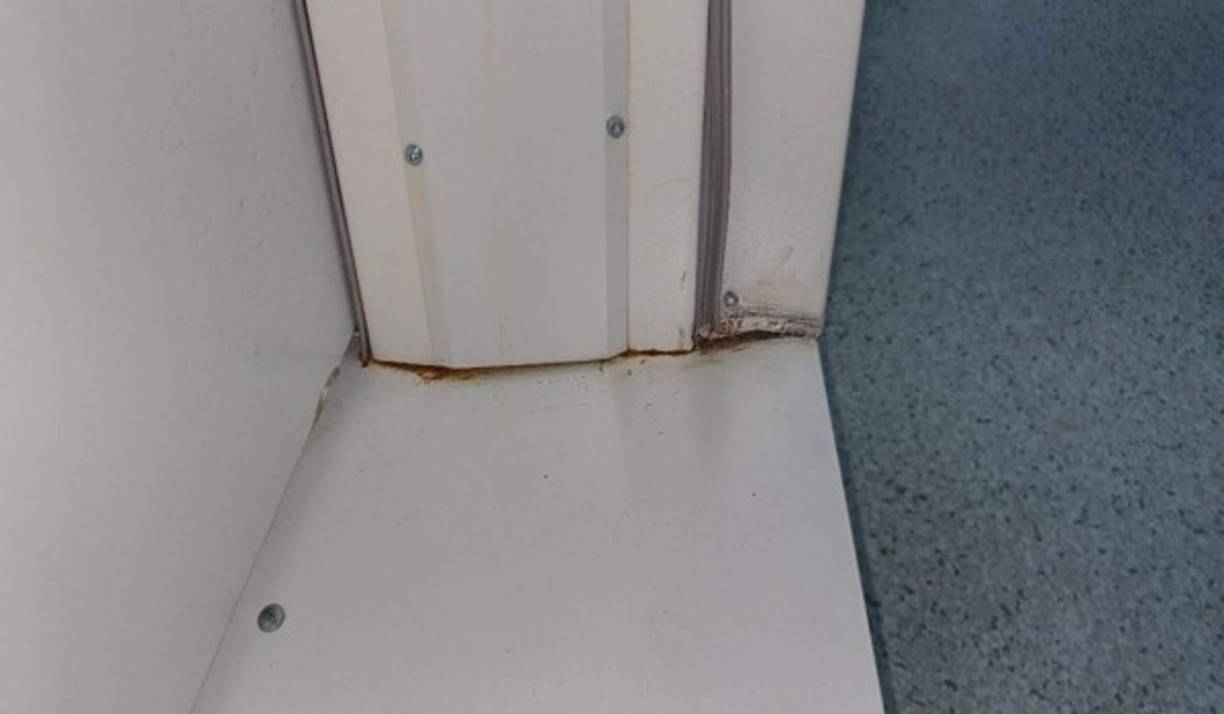 Óxido y corrosión en juntas de paneles de puertas de accesos de todo el hospital.