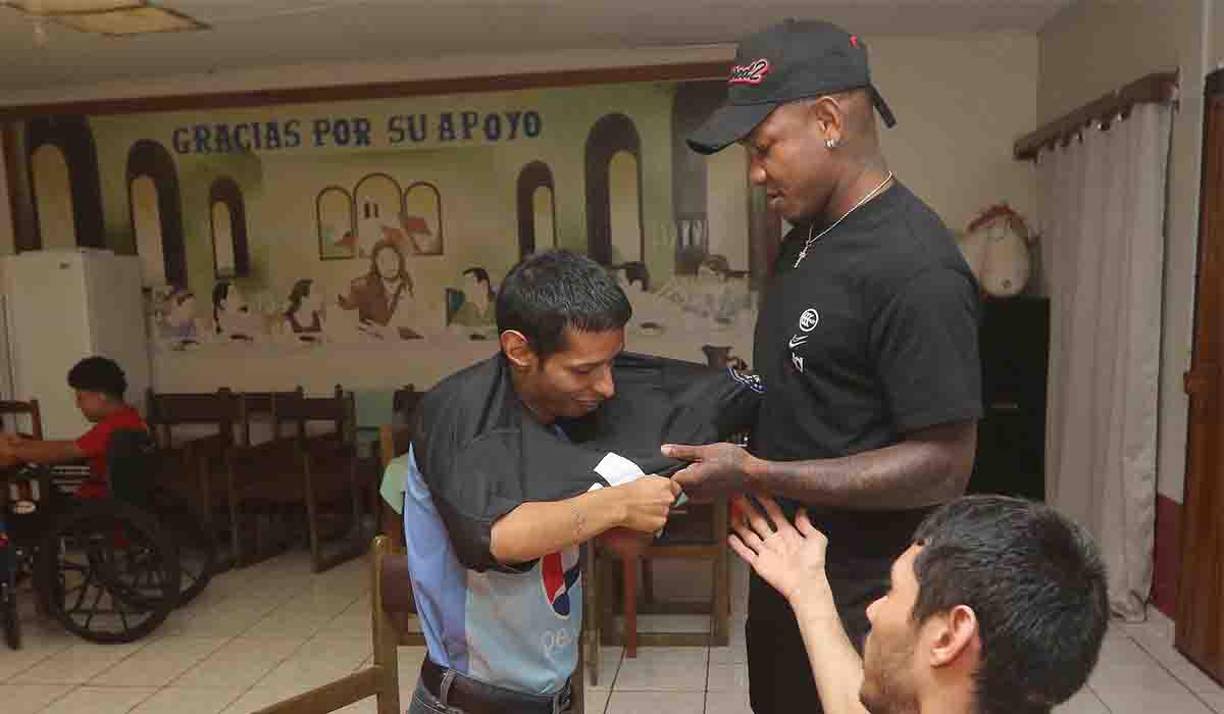Romell Quioto se dio la tarea de ponerle la camiseta a una de las personas que forman parte de la Casa Hogar.
