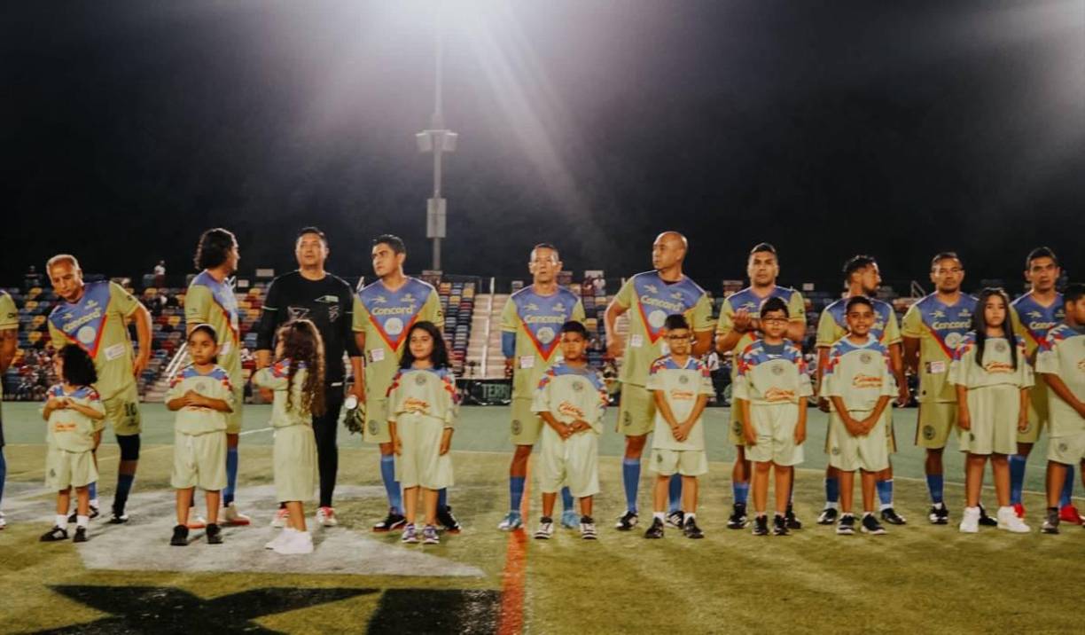 Los jugadores del América al momento previo de iniciar el partido y compartir con las niñas.