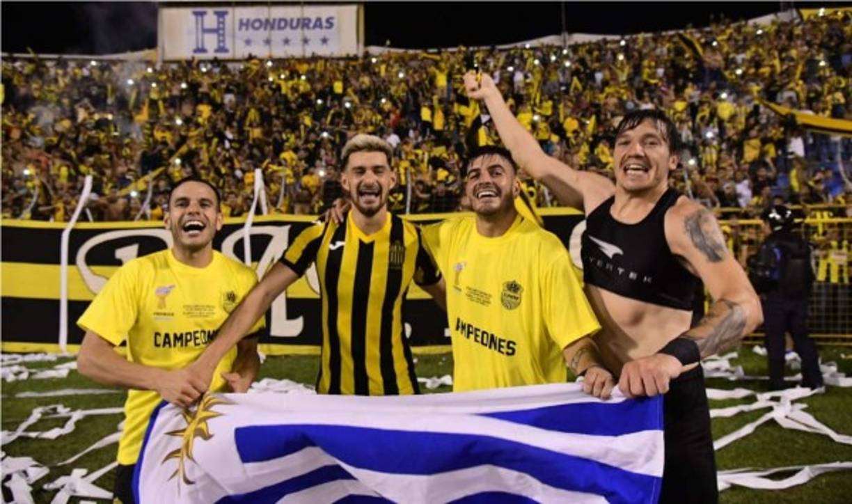 Los uruguayos del Real España, Santiago Correa, Pablo Pírez, Delis Vargas y Matías Soto, festejando con la bandera de su país.