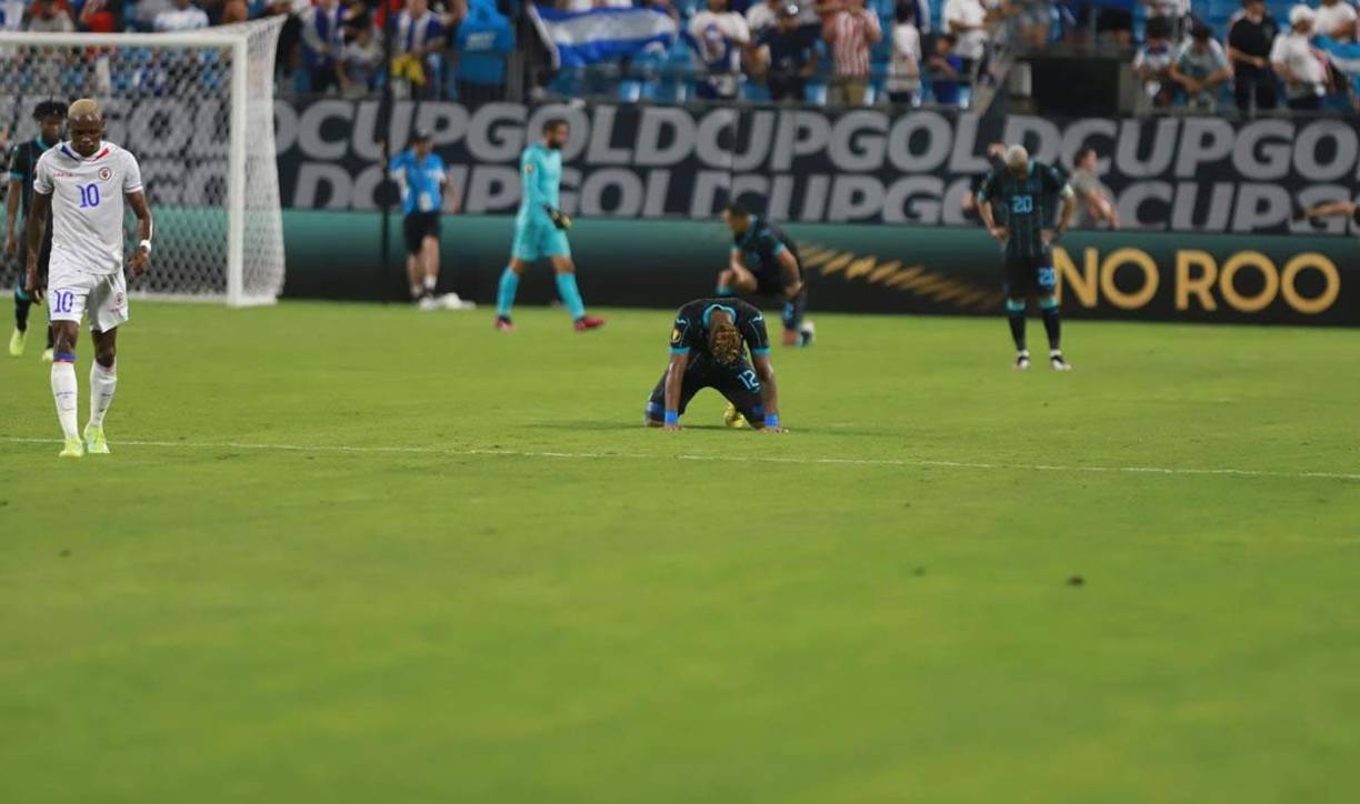 Los seleccionados hondureños abatidos en el campo tras el final del partido ante Haití.