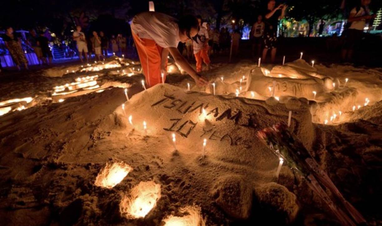 Velas en una escultura de arena se ven durante la conmemoración del décimo aniversario del tsunami de 2004 en la playa de Patong, en la provincia de Phuket.